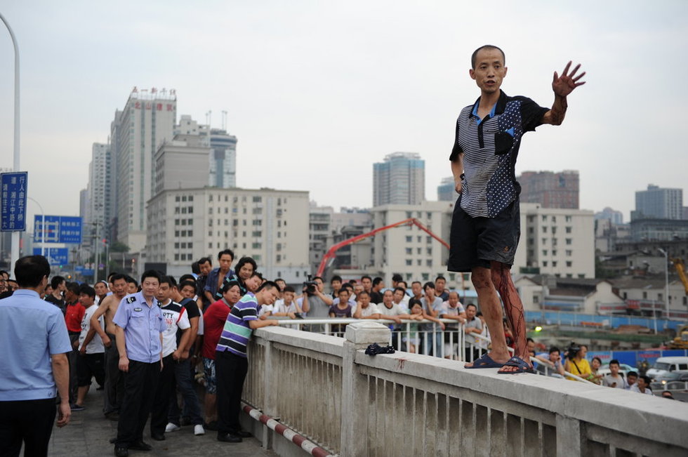 图为7月13日下午,男子手持匕首爬上长沙湘江一桥欲自寻短见.